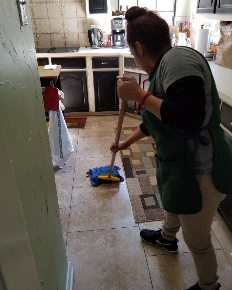 R U Helens team member mopping a kitchen floor